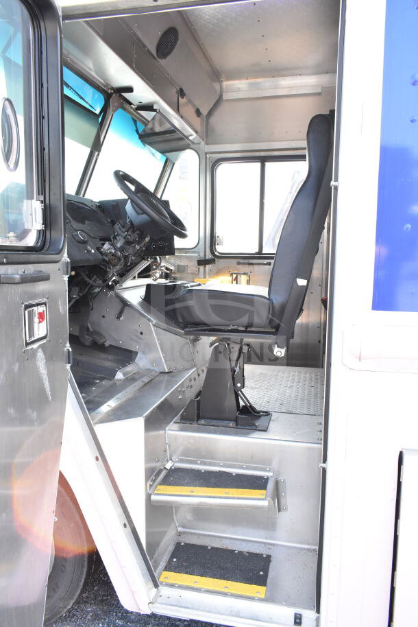 2020 Ford F59 food truck interior view; driver seat, steering wheel, and metal step entry visible.