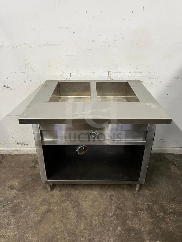 24" electric stainless steel steam table with dual compartments, open storage below, in used condition.