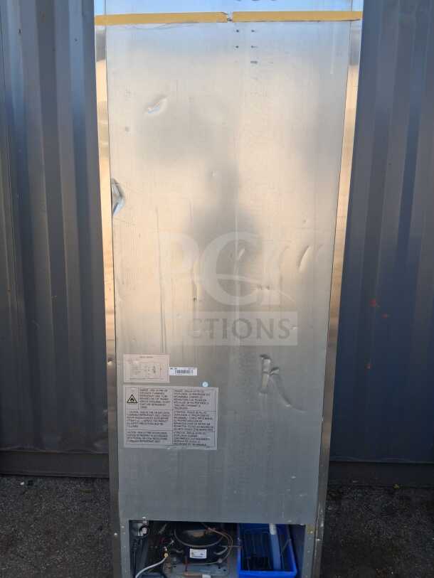 Back panel view of Dukers D28R 27.5" reach-in refrigerator, showing dents, wiring, and warning labels. Right hinge door model.