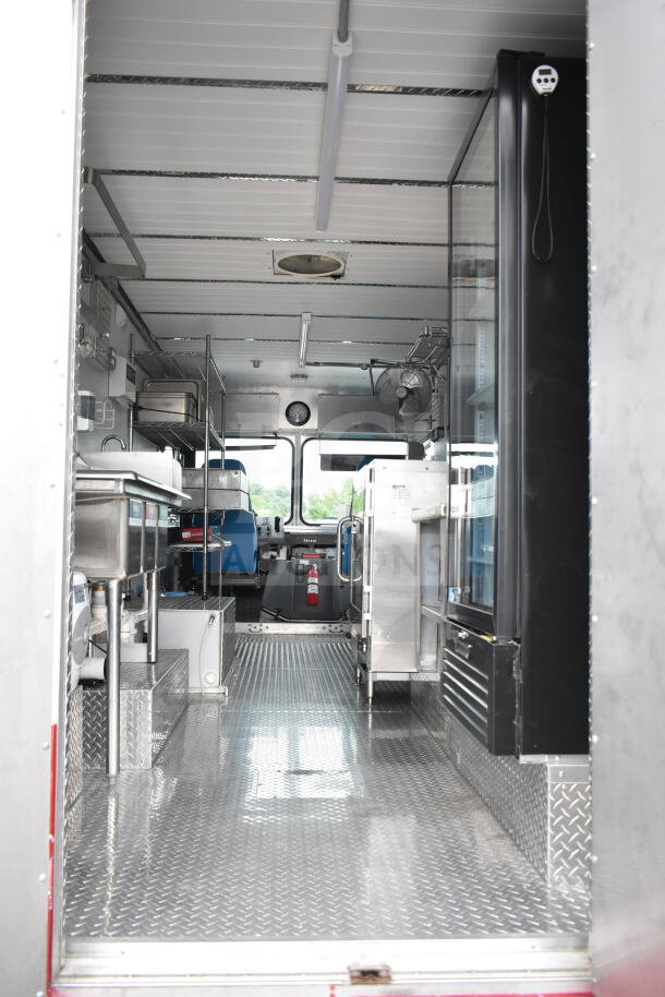 1993 GMC Step Van interior with metal shelving, stainless steel sink, and equipment, showcasing clean, organized space. VIN 1GDHP32K7R3500033.