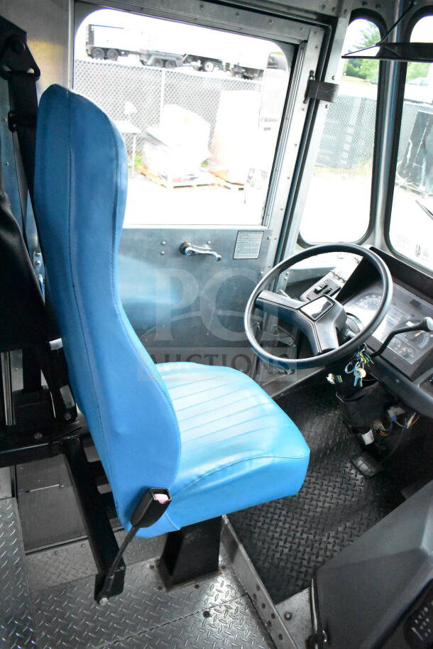 1993 GMC Step Van interior, featuring blue driver's seat, steering wheel, and dashboard. VIN 1GDHP32K7R3500033.