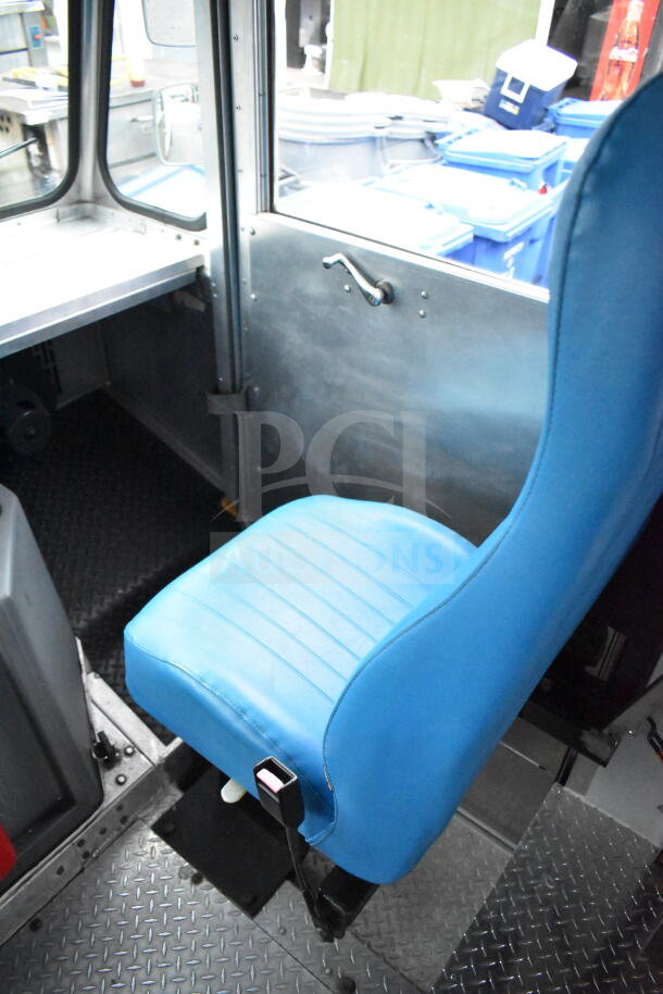 Interior of 1993 GMC Step Van, featuring a blue driver's seat in good condition and diamond plate flooring.