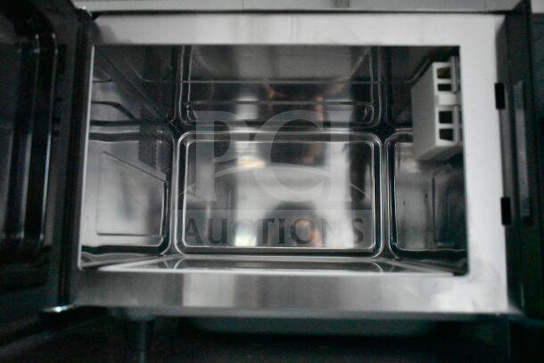 Interior view of a stainless steel oven. Clean, unused condition.