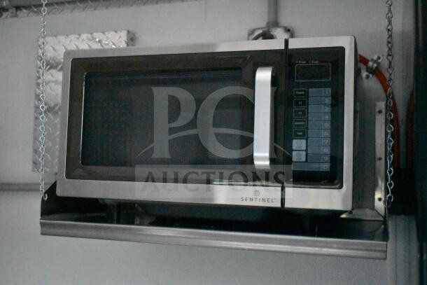 Stainless steel Sentinel microwave mounted inside a GMC Step Van, featuring a digital keypad and pull handle.