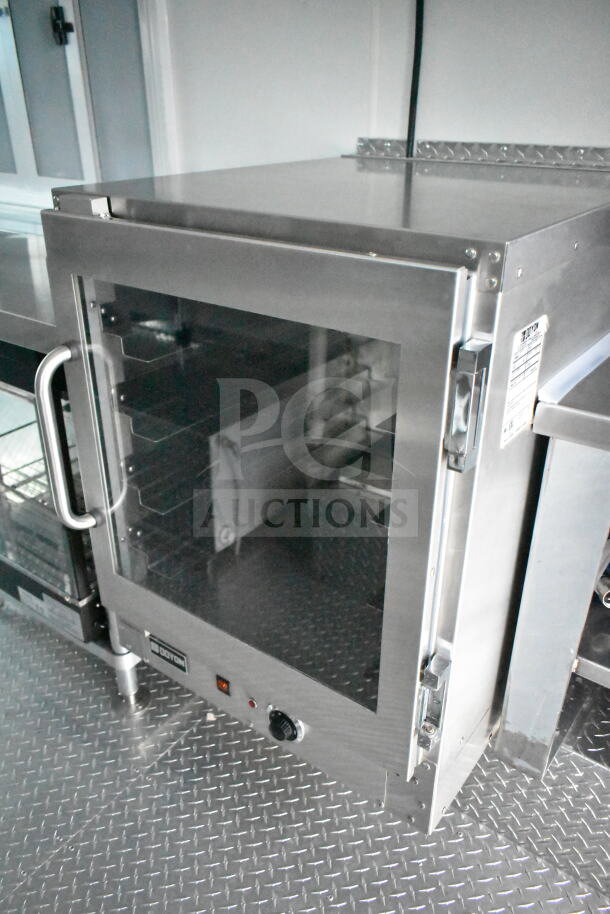 Stainless steel oven inside 1993 GMC Step Van, featuring a glass door with metal handle and visible control knob.