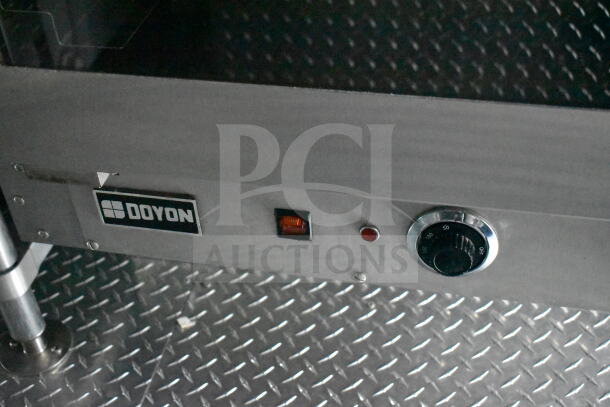 Interior view of a 1993 GMC Step Van, featuring a Doyon branded stainless steel appliance with control knobs and indicators.