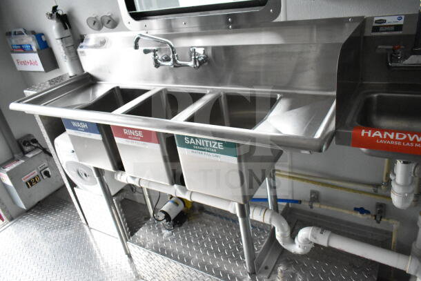 Interior of 1993 GMC Step Van showing a stainless steel three-compartment sink labeled Wash, Rinse, Sanitize, with a handwash area and plumbing.