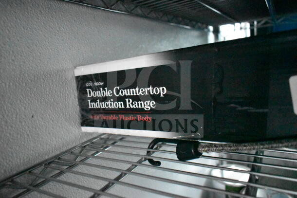 A "Double Countertop Induction Range" box with 120V/1800W label, featuring a durable plastic body, on a metal shelf.