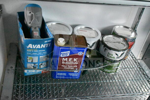 Assorted painting supplies on a metal shelf, including an Avanti paint sprayer and Klean Strip M.E.K. Substitute can.