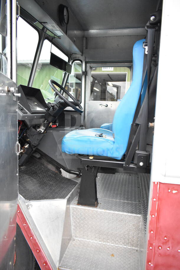 Interior of 1993 GMC Step Van, featuring a blue driver's seat, metal flooring, and steering wheel. VIN: 1GDHP32K7R3500033.