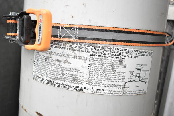 "Warning label on GMC Step Van with safety instructions and diagram, secured by orange and black strap."