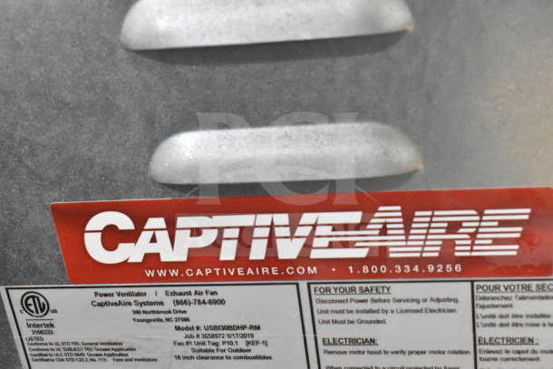CaptiveAire USBI30BDHP-RM commercial exhaust fan with label and safety instructions, model visible, suitable for outdoor use.