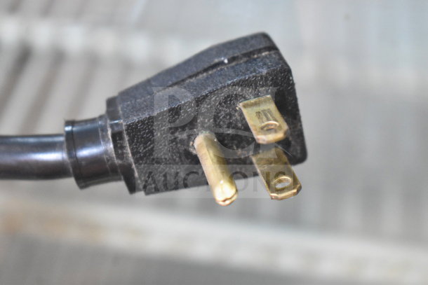 Close-up of a three-prong plug of True GDM-12 cooler, 115 volts, 1 phase, indicating standard electrical compatibility.