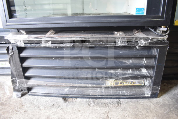 True GDM-26 commercial single door reach-in cooler merchandiser, black exterior, visible wear, True logo, 115 volts, 1 phase.