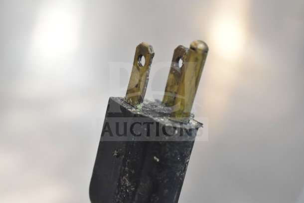 Close-up view of a worn electrical cord plug from a commercial floor style braising pan, showing signs of use.