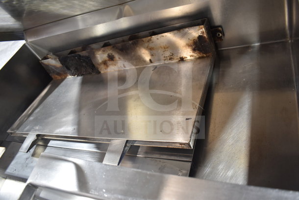 Commercial floor style braising pan, stainless steel, visible wear marks, sturdy construction ideal for high-volume cooking.