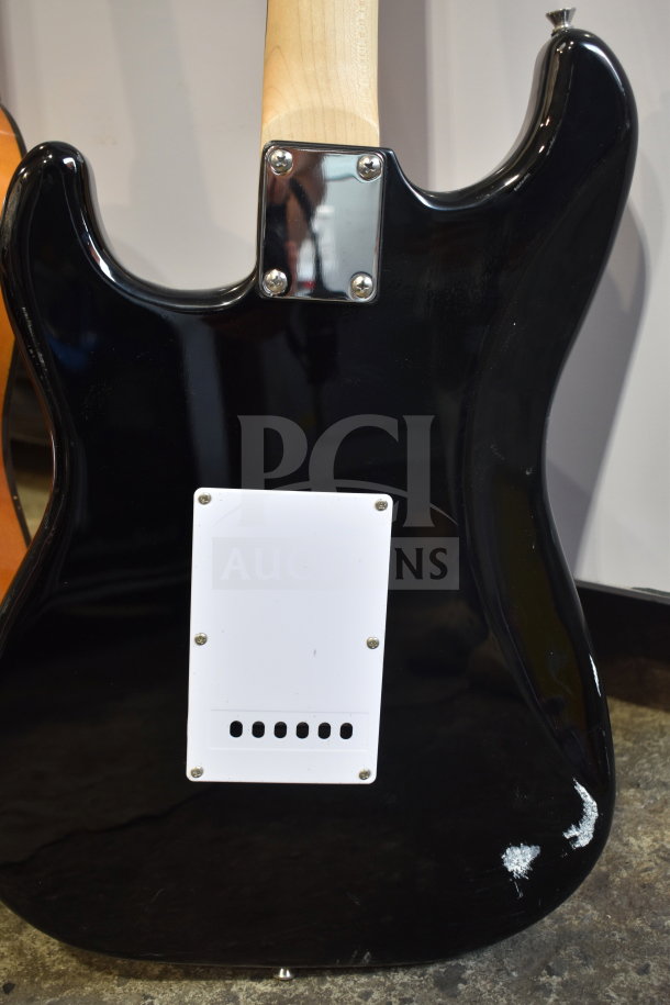 Two Rock Jam electric guitars with a glossy black finish, visible wear on the body, mounted metal neck plate.
