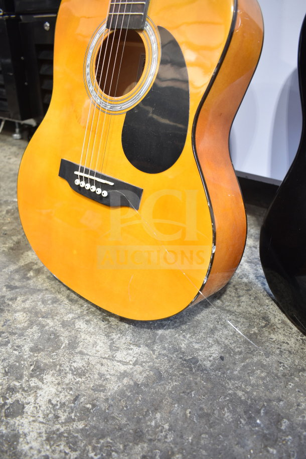 Two Rock Jam acoustic guitars, natural wood finish, dual bidding opportunity, visible scratches and wear, ideal for collectors.