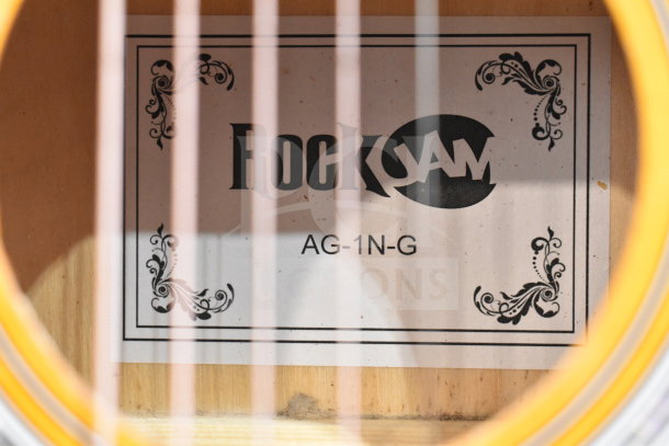Rock Jam acoustic guitar label inside the soundhole, model AG-1N-G, showcasing intricate decorative borders.