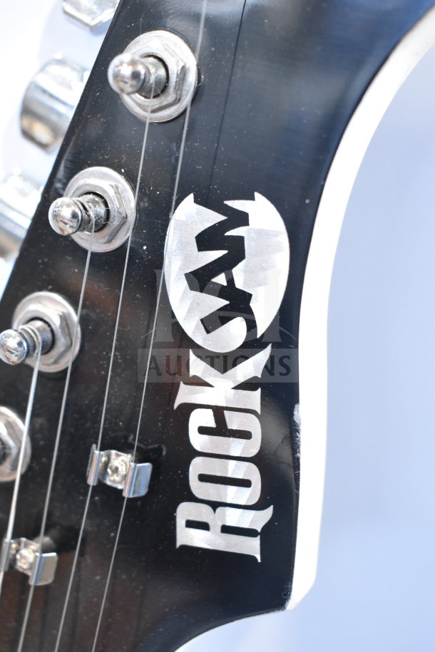 Rock Jam guitar headstock with tuning pegs, showing "Rock Jam" logo, indicating brand and authenticity.