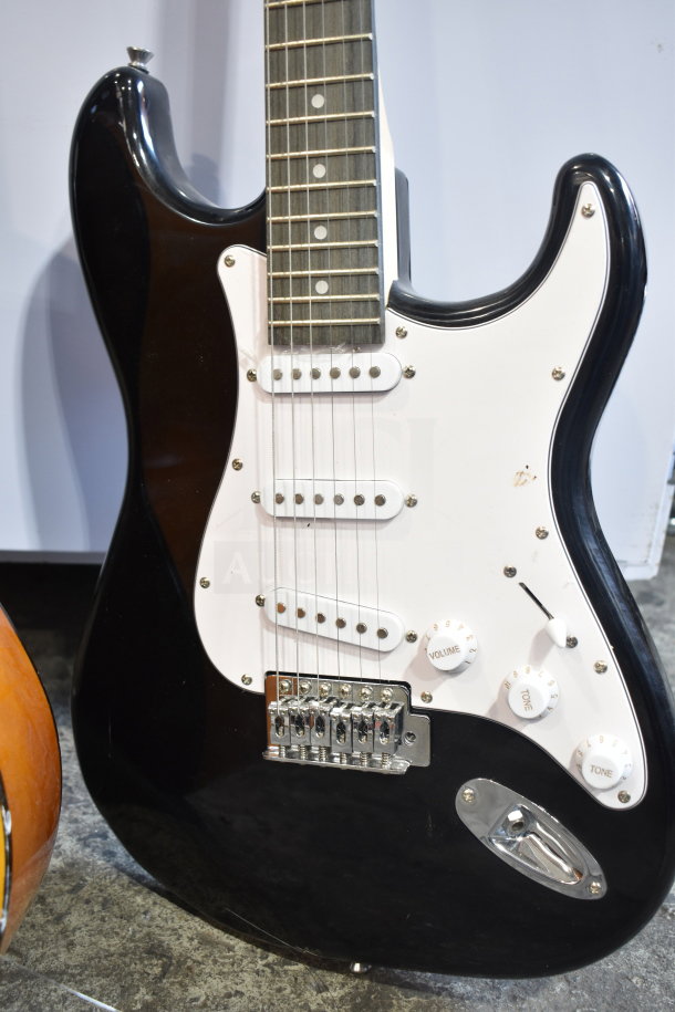 Two Rock Jam electric guitars, black body, white pickguard, three single-coil pickups, volume and tone knobs, in good condition.