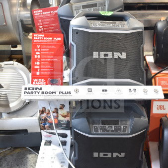 4 Ion Party Boom Plus speakers in a store display, featuring robust design, wireless Bluetooth, multi-colored lights, and microphone compatibility.
