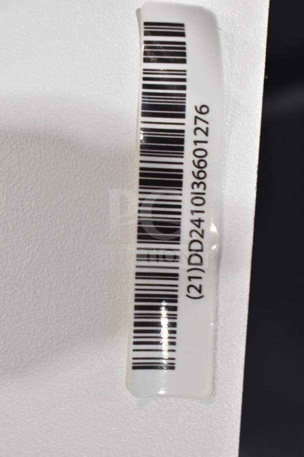 Barcode sticker on a white surface with the code (21)DD2410136601276, likely for inventory or tracking purposes.