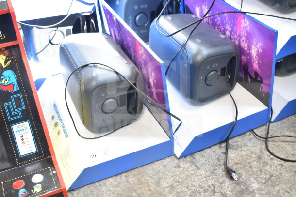 Two Onn medium party speakers in-store display, boxed, showing front controls and black finish, cables visible.