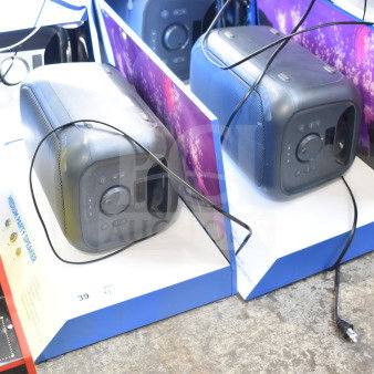 Two Onn medium party speakers in-store display, boxed, showing front controls and black finish, cables visible.