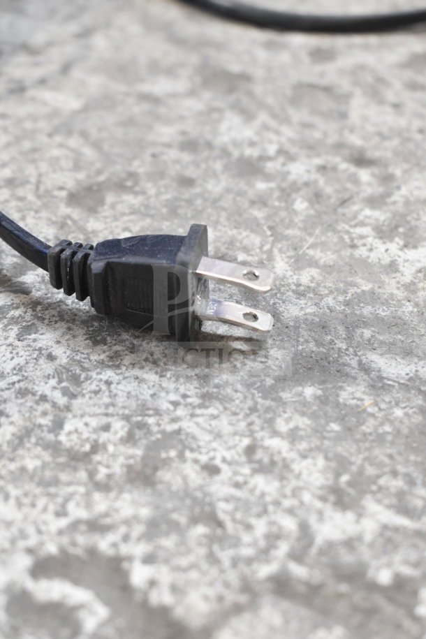 Power cable photographed on a gray textured surface, likely part of Onn Medium Party Speaker display.