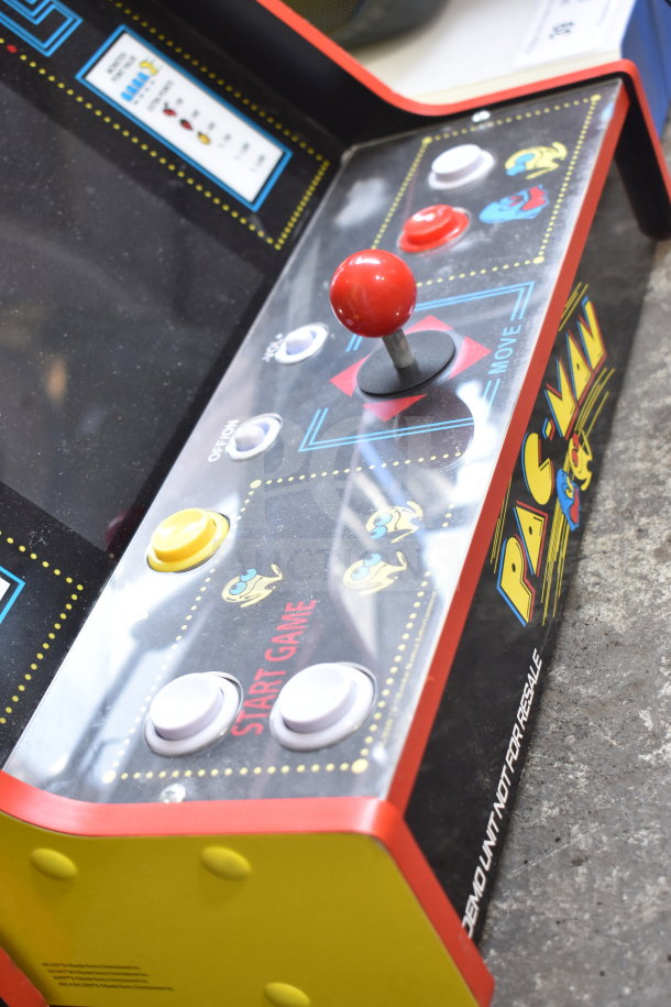 Arcade 1UP PAC-A-501030 Pac Man Machine with joystick and control buttons, "Pac Man" logo visible, "DEMO UNIT NOT FOR RESALE" marking.
