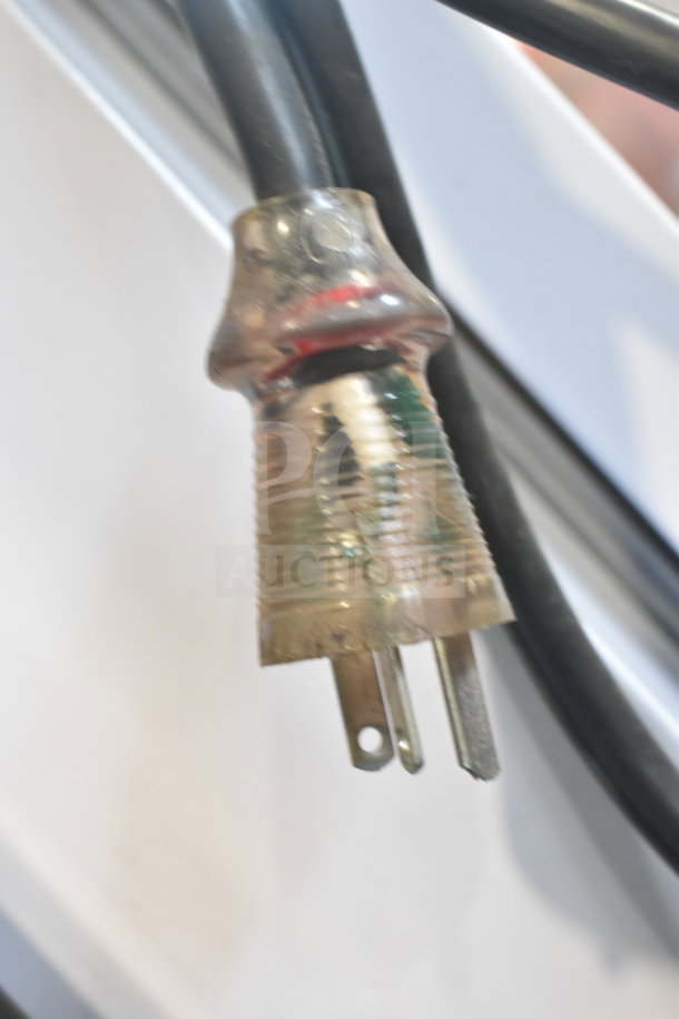 Close-up of a power plug attached to the Migali EVOx-1F commercial freezer. Black cable, three-prong connector.