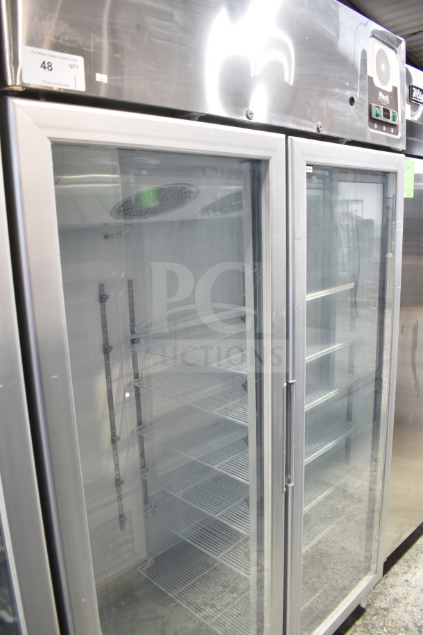 Alt Text: Migali G-2RG-A commercial 2-door reach-in cooler with glass doors and shelving, scratch and dent, on casters.