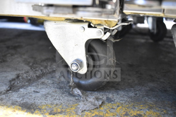 Migali G-2RG-HC cooler's commercial caster wheel on concrete floor, showcasing mobility.