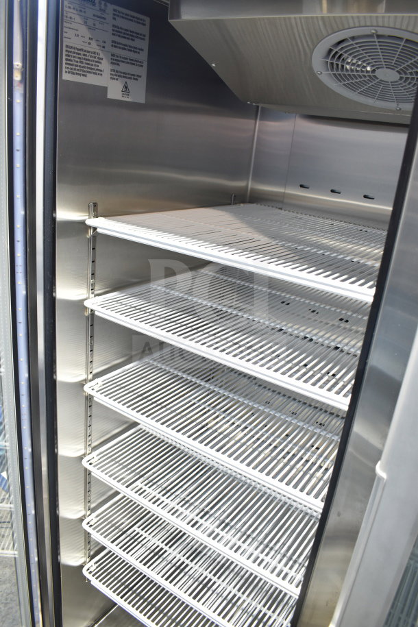 Brand new Migali G-2RG-HC cooler, two-door, commercial casters, shelves visible, 115V, slight dents.