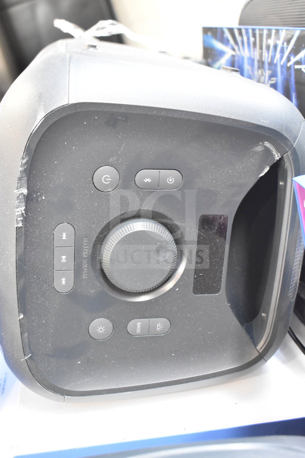 Onn Large Party Speaker control panel with power, Bluetooth, volume, and bass buttons. Slight wear visible. Model for store display.