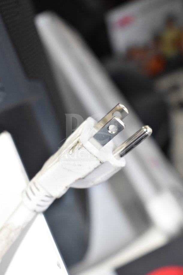 Close-up image of a standard white electrical plug connected to an electronic device. Details of device not shown.