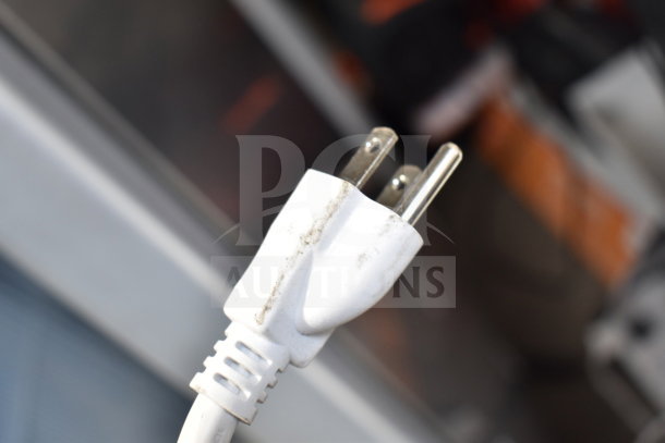 White power plug with visible wear, part of a store display set including an Ion speaker.