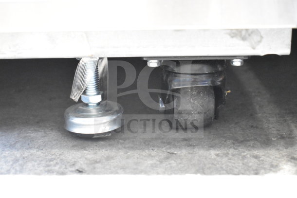 Migali G-1MRG-HC reach-in cooler on commercial casters, emphasizing sturdy wheel and support structure underneath.