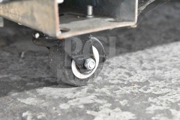 Close-up of caster from Migali C-72FM 3-door freezer merchandiser, showcasing sturdy commercial wheel.