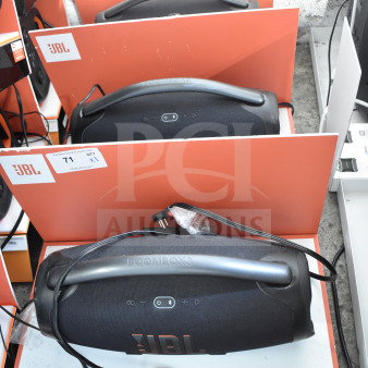Three JBL Boombox 3 speakers on store display. Features include massive sound, waterproof design, and deep bass.