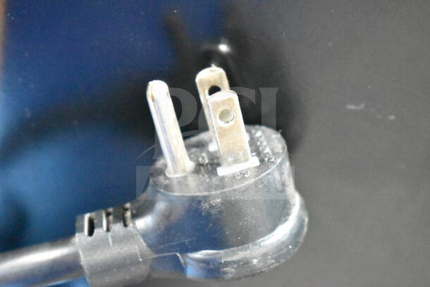 Close-up of a 3-prong electrical plug for the True GDM-49-HC commercial cooler, 115 volts, indicating power compatibility.