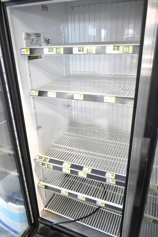 2016 True GDM-72F-HC commercial 3-door reach-in freezer with adjustable wire shelves and visible manufacturer label.