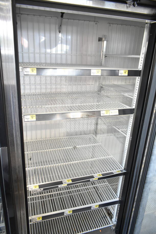 2016 True GDM-72F-HC Commercial 3 Door Reach In Freezer, metal shelves, price tags visible, clean condition.