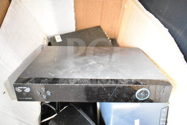 Box with electronics including Night Owl 8 Channel 960H DVR, visible scratches, used condition, surrounded by other items.