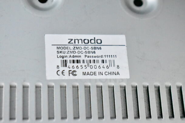 Zmodo ZMD-DC-SBN6 DVR unit with model and SKU label, login info, and barcode. Made in China, CE, and FCC marked.