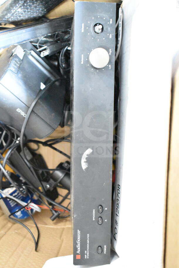 Box of various electronics including an AudioSource AMP100 Stereo Power Amplifier, Epson receipt printer, and cables.
