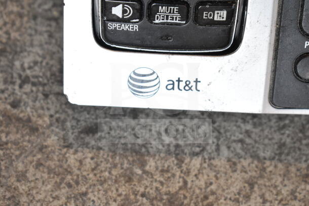 AT&T speaker phone detail with logo, showing "Mute/Delete" and "EQ" buttons. Phone appears slightly worn.