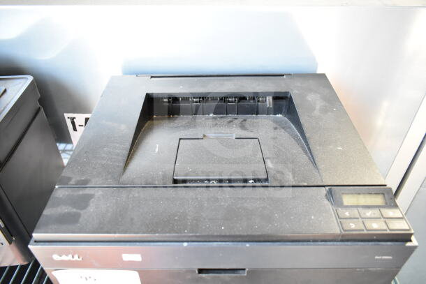 Dell 2350dn Countertop Printer; black, compact design, visible dust, control panel with buttons, suitable for office use.