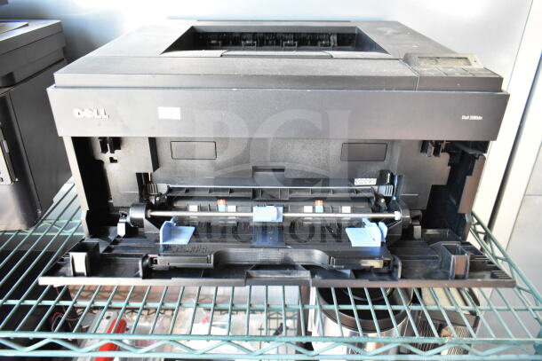 Dell 2350dn countertop printer, black, with open paper tray, visible internal rollers. Good condition. Model number on side.